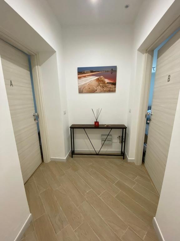 korytarz z dwoma drzwiami i stołem w obiekcie G’S HOME w mieście Margherita di Savoia