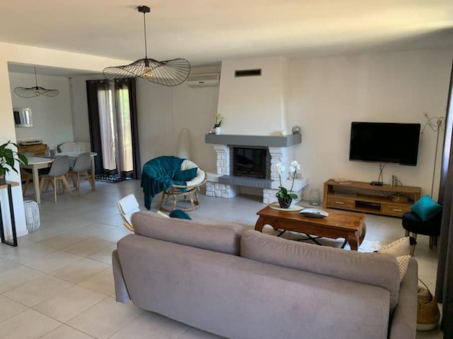 Una sala de estar con un sofá y una chimenea. en Maison avec jardin proche Avignon 2 chambres, en Les Angles