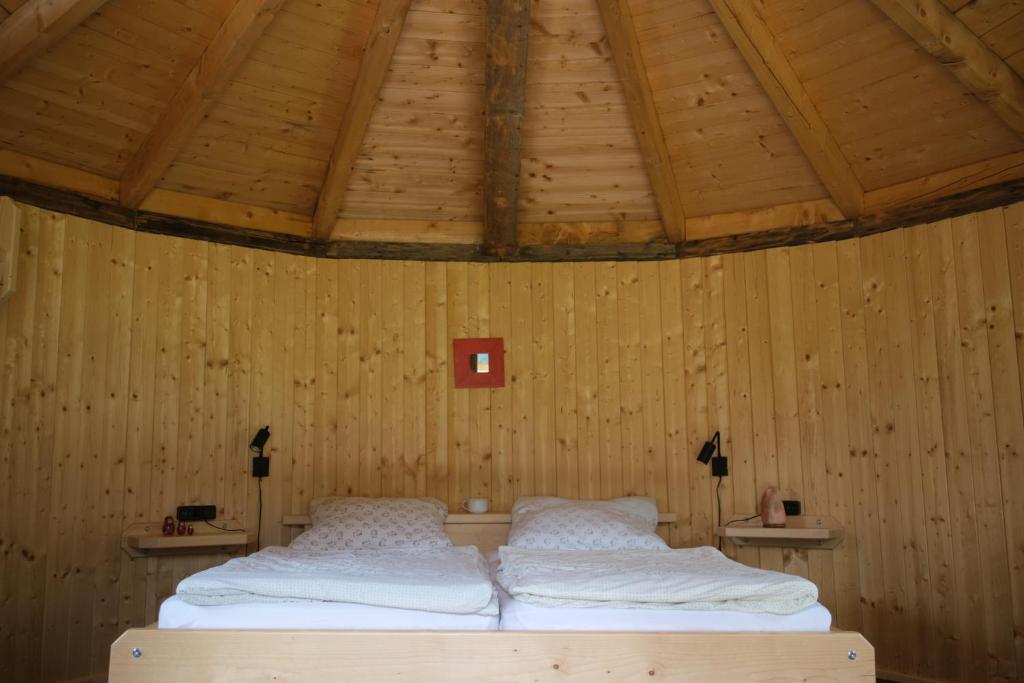 a bedroom with two beds in a wooden ceiling at Holzjurten by JULKA - self checkin in Finkenstein