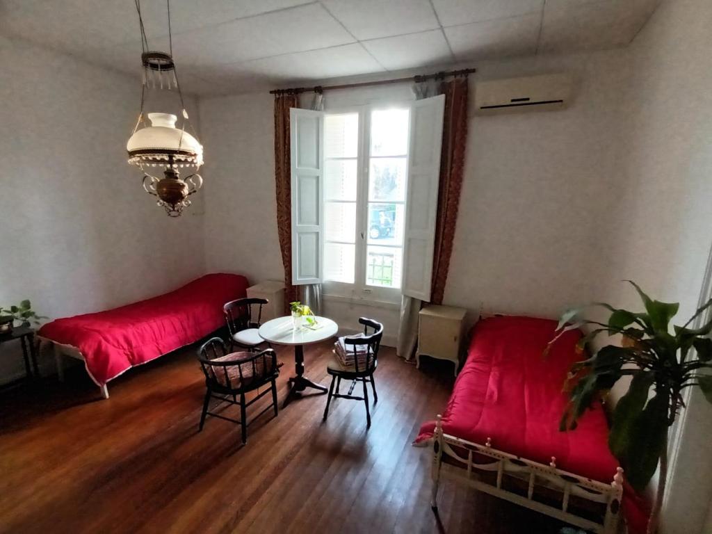 sala de estar con sofá rojo y mesa en Casa Pellegrini - Hostel en San Pedro