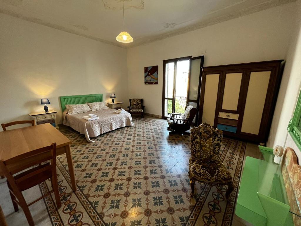 - une chambre avec un lit, une table et des chaises dans l'établissement Mille Lire, à Palerme