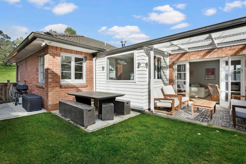a backyard with a table and chairs and a house at Renovated Character Central Home - WiFi & Netflix in Auckland