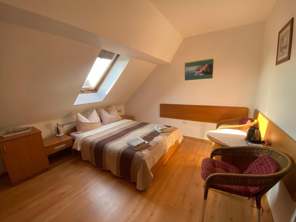ein Schlafzimmer mit einem Bett, einem Stuhl und einem Fenster in der Unterkunft Dom Gościnny Relax in Rewal