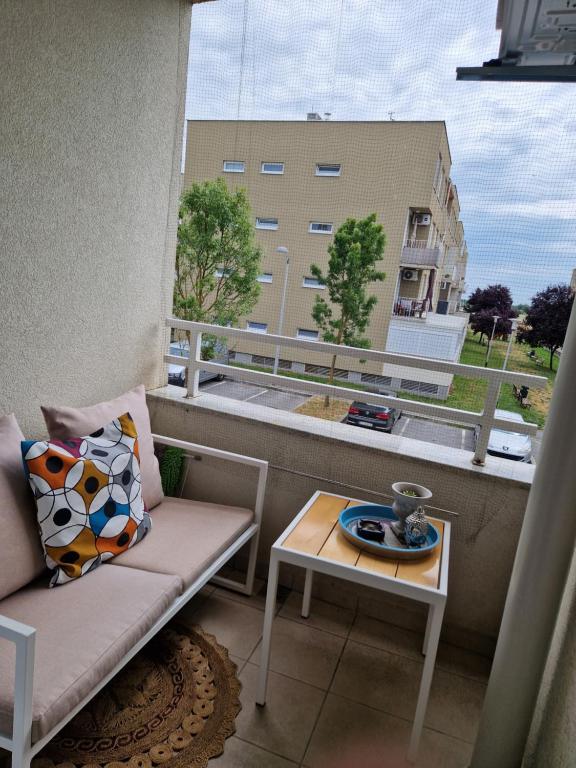 d'un balcon avec un canapé, une table et une fenêtre. dans l'établissement Apartment Rose, à Sesvete