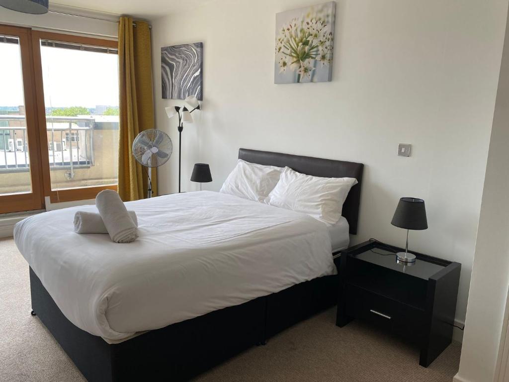 a bedroom with a large bed with a window at Spacious 2 Bedroom Apartment at The PostBox in Birmingham