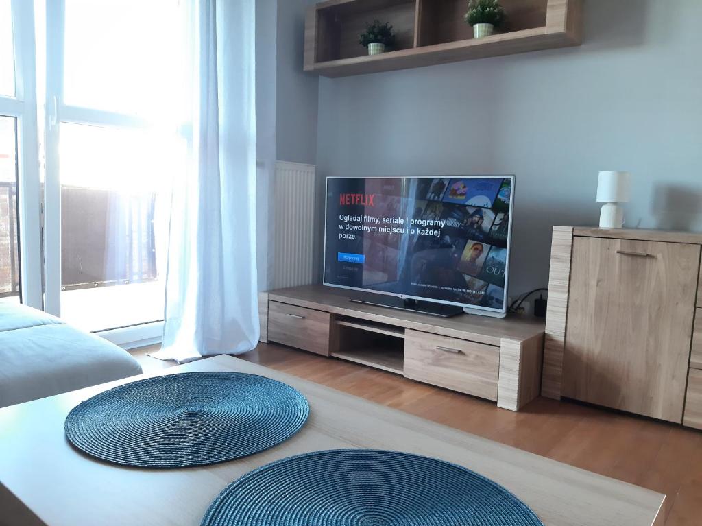 a living room with a tv and a table at Apartament Borkowo in Borkowo