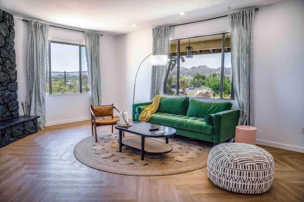 a living room with a green couch and a table at Mojave Desert Pied-à-terre in Yucca Valley