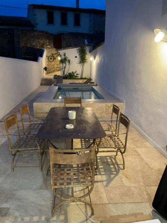 a patio with a table and chairs and a pool at Gite sur la Founintrouze in Fabrezan
