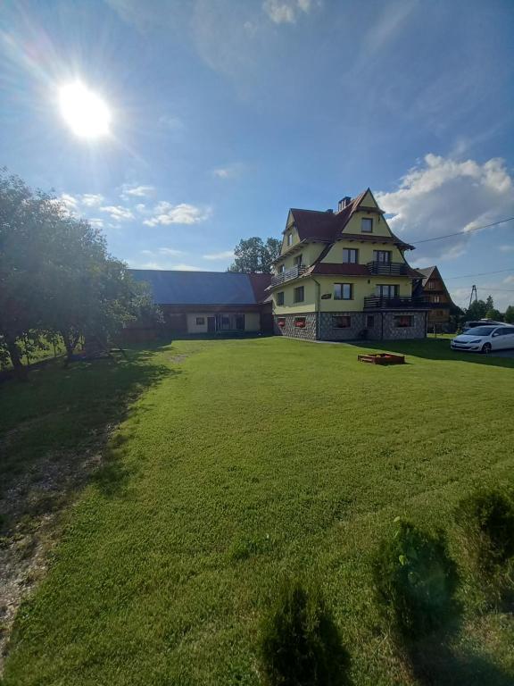 un gran campo de hierba frente a una casa en Pokoje gościnne "u Marysi", en Chochołów