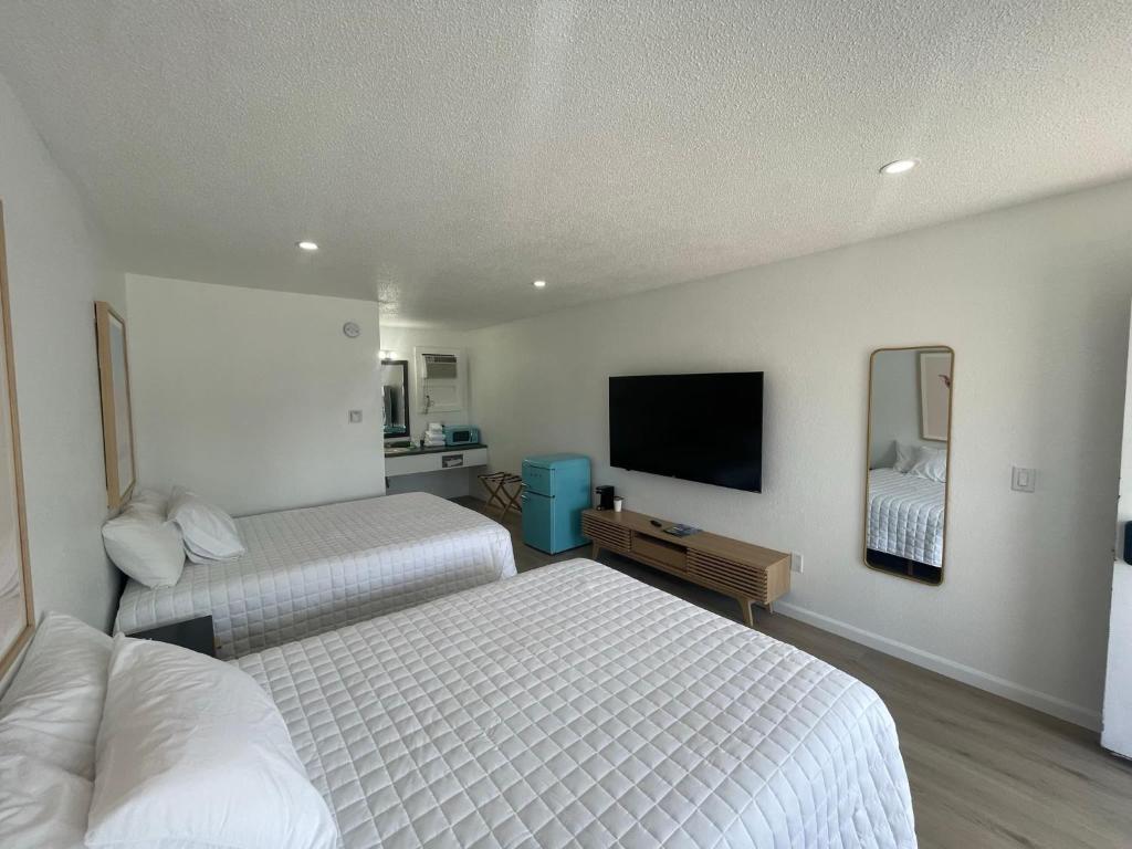 ein Hotelzimmer mit 2 Betten und einem Flachbild-TV in der Unterkunft Double Room in Lake City