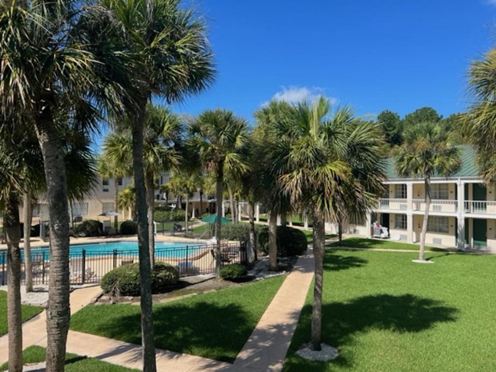 a resort with a swimming pool and palm trees at Windsor Inn of Jacksonville in Jacksonville