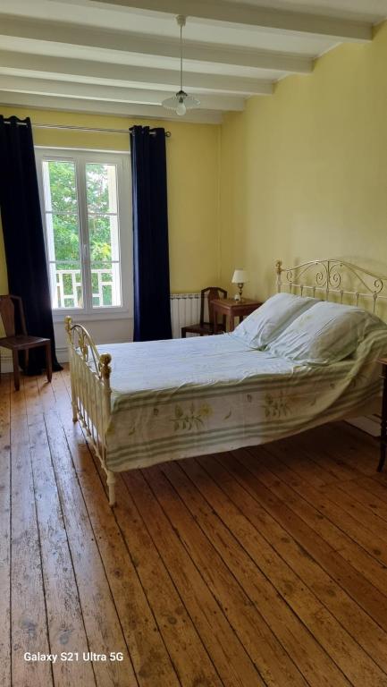 a bedroom with a large bed with a wooden floor at Logis de Pagnolet in Ozillac