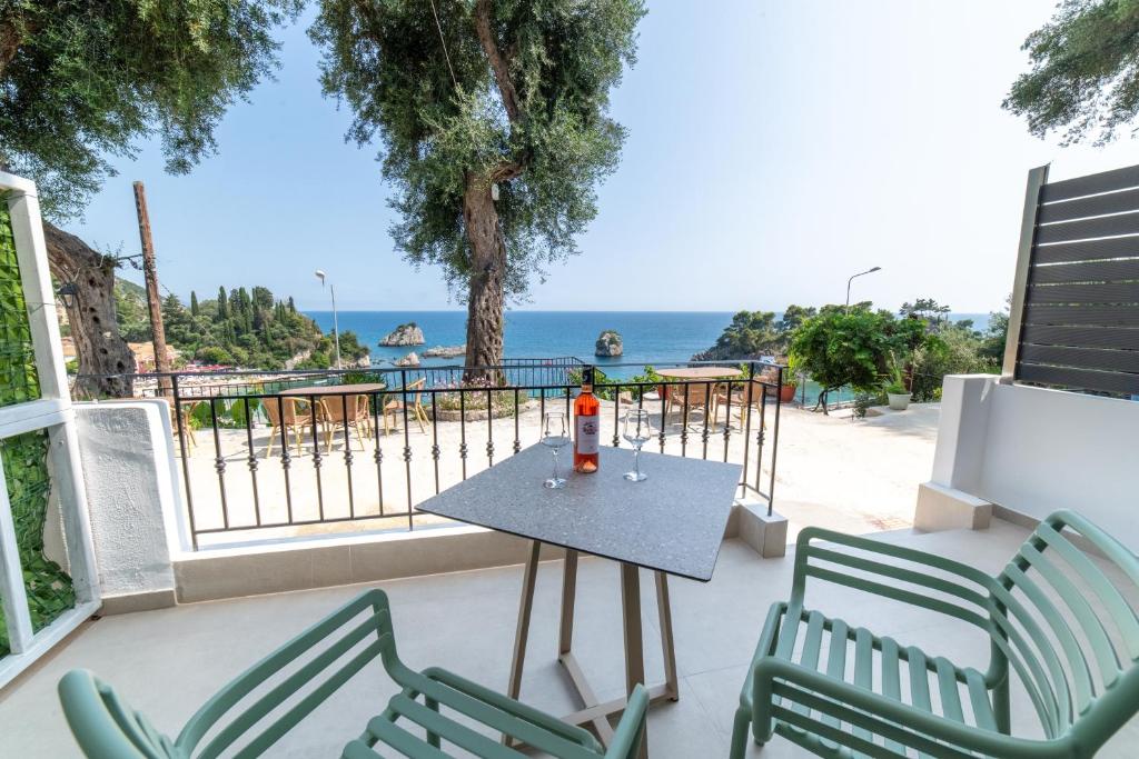 een tafel en stoelen op een balkon met uitzicht op de oceaan bij Lithitsa Lofts and Suites in Parga