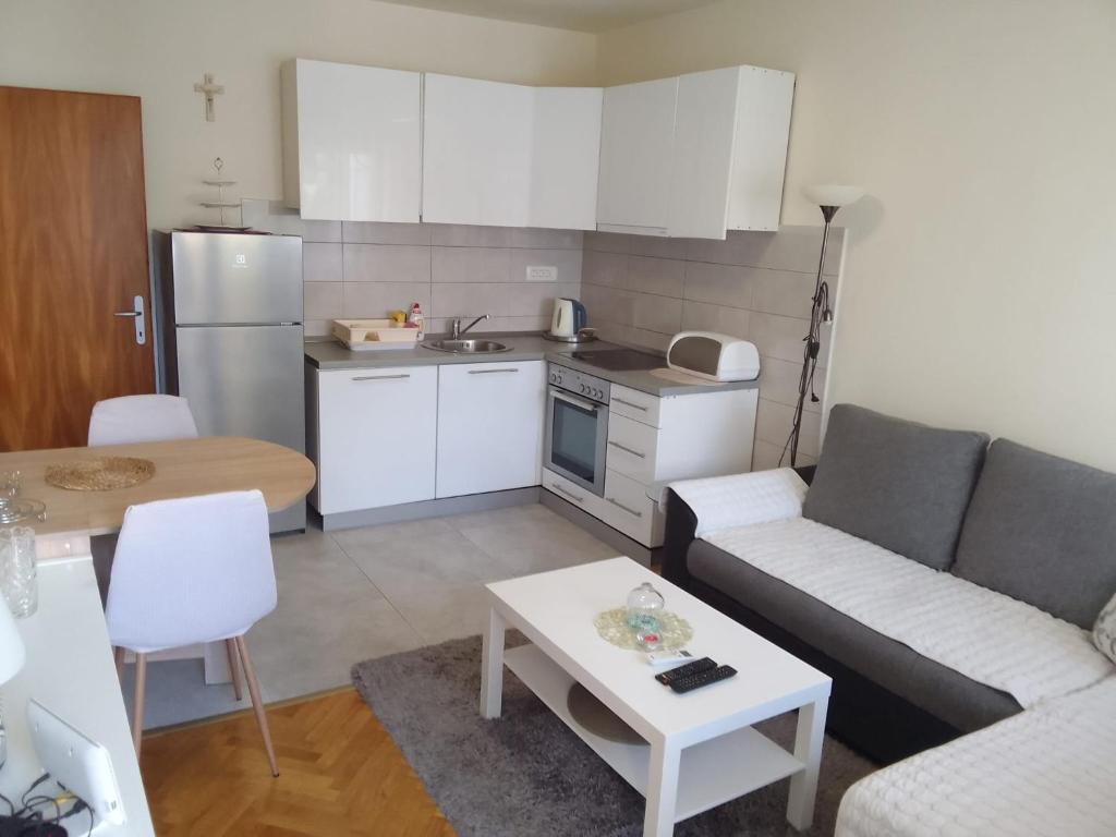 a small kitchen and living room with a couch and a table at Apartment Italiano in Split