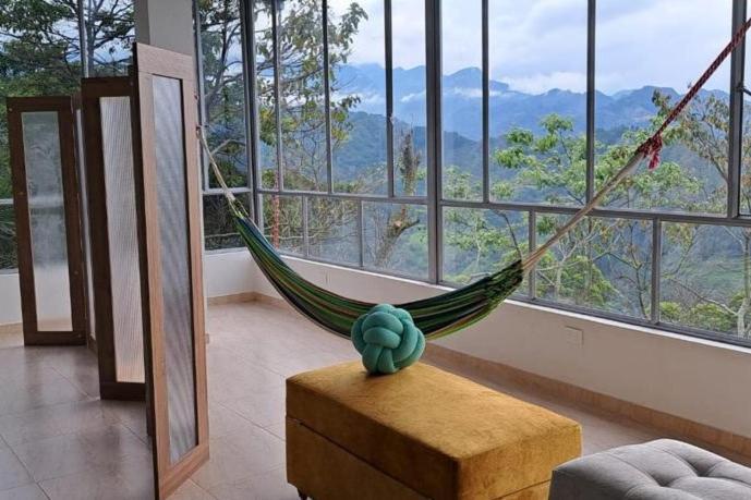 a hammock in a room with a large window at Estancia Don Heli in San Francisco