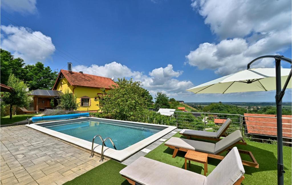 a swimming pool with a table and an umbrella at 3 Bedroom Pet Friendly Home In Ludbreg in Ludbreg