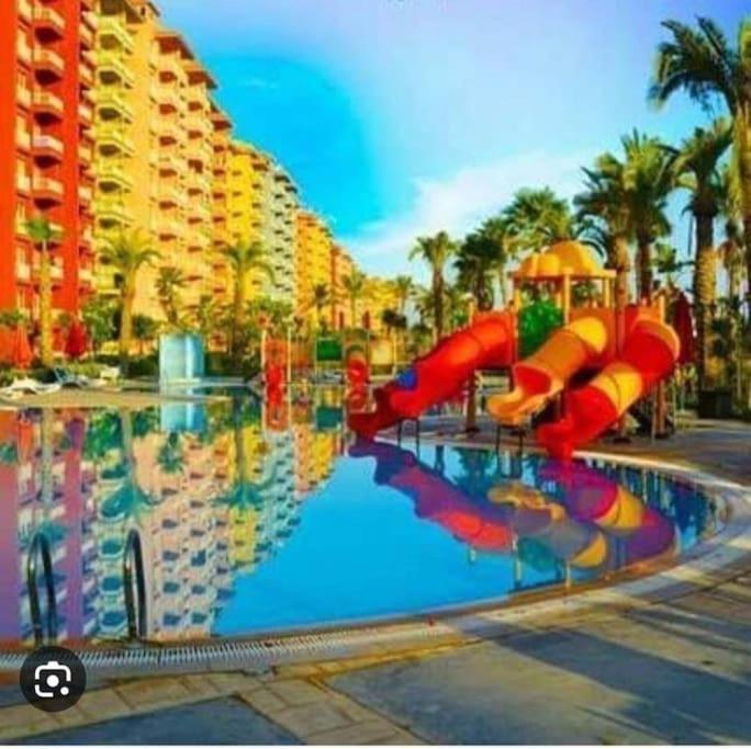 a pool with a water slide in a resort at استديو فى بورتو جولف مارينا in El Alamein