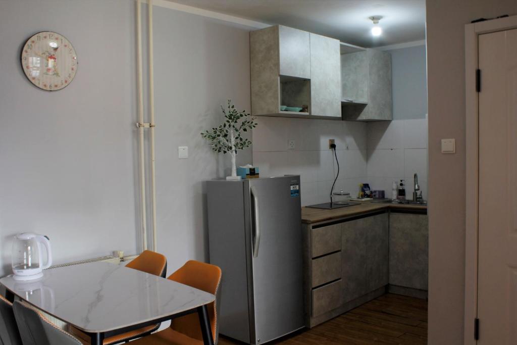 a kitchen with a stainless steel refrigerator and a table at Tsatsa in Ulaanbaatar