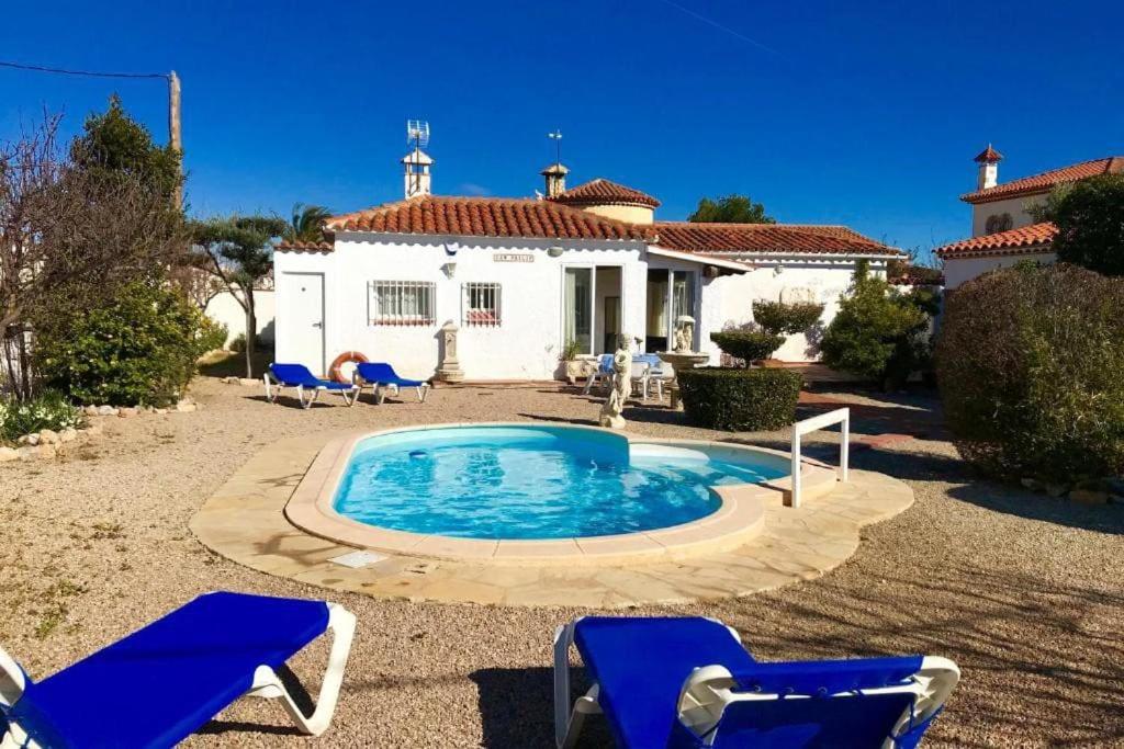 a pool in front of a house with blue chairs at VILLA PHILIP Piscina privada in Miami Platja