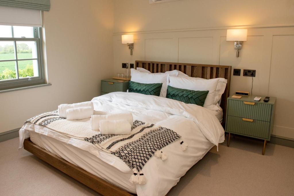 a bedroom with a large bed with white sheets and pillows at The Flag in Wivenhoe