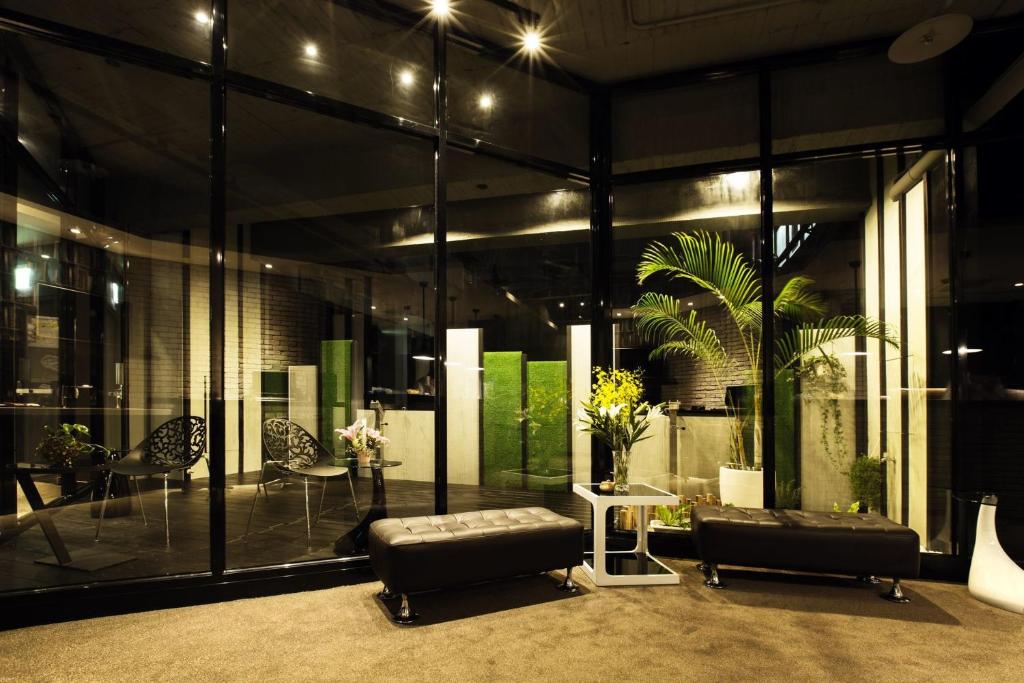 a lobby with two black leather chairs and a table at Queens Hotel II in Taipei