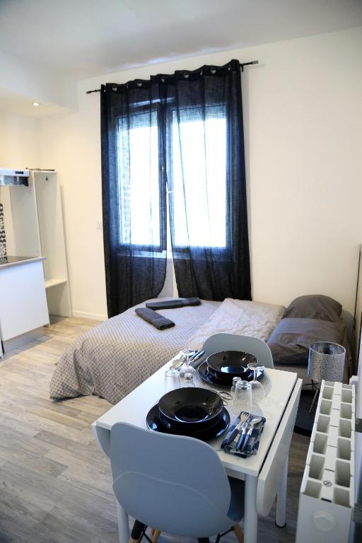 Cette chambre comprend un lit et une table avec deux chaises. dans l'établissement Mars, à Saint-Quentin