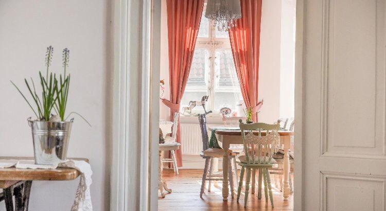 a dining room with a table and chairs in a room at Kobieciarnia in Tczew