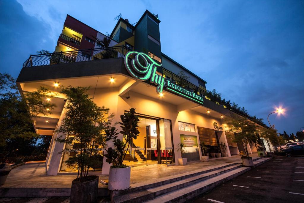 a store with a neon sign on the side of it at Thy Executive Hotel in Johor Bahru