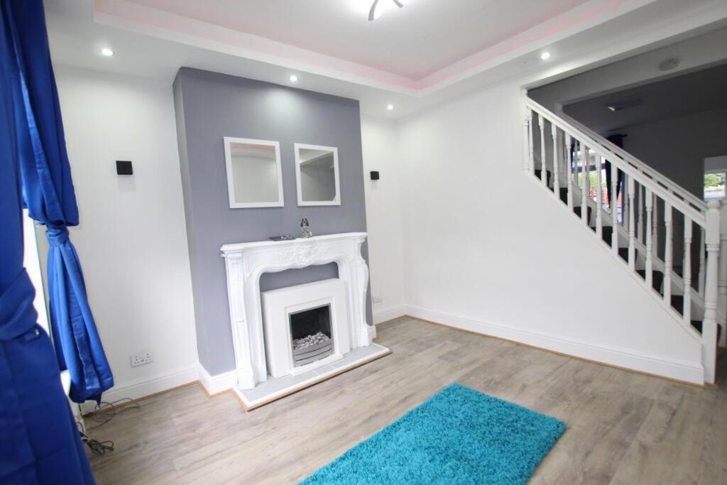 a living room with a fireplace and a staircase at Friendly Stockport in Stockport