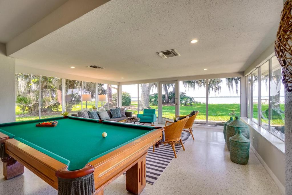 a pool table in a room with windows at Luxe Waterfront Oasis with Dock - Direct Lake Access! in Tavares
