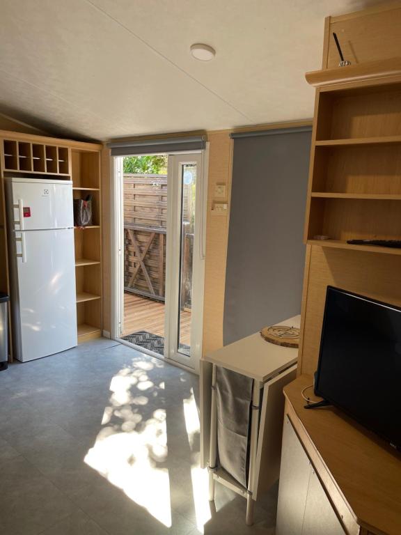 une cuisine avec un réfrigérateur et une porte coulissante en verre dans l'établissement Mobil home 42 m2 europcamping, à Fréjus
