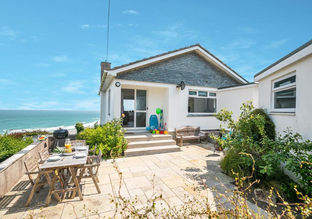 a house with a patio with a table and chairs at Trecarrack Carthew Way in St Ives
