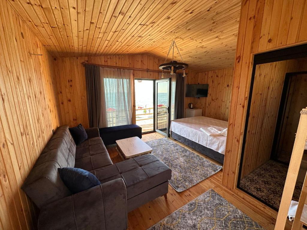 ein Wohnzimmer mit einem Sofa und einem Bett in einer Hütte in der Unterkunft Black Sea Beach Bungalow in Akcakoca