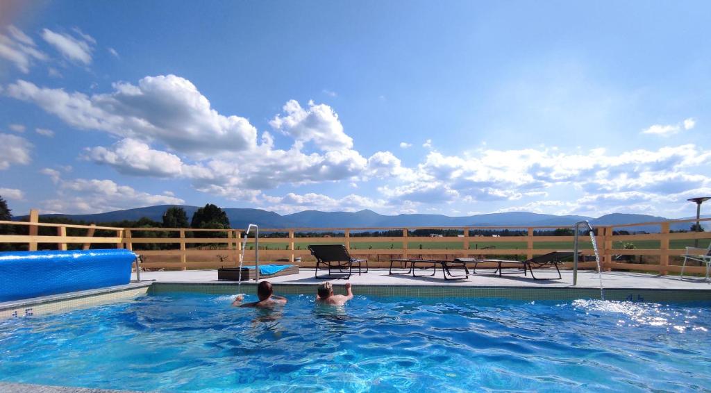 two people are swimming in a swimming pool at Willa Kolorowa Chata in Mysłakowice