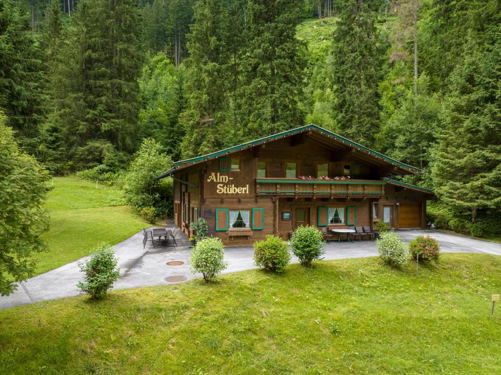 un grand bâtiment en bois au milieu d'une forêt dans l'établissement Schiestl's Almstüberl, à Mayrhofen