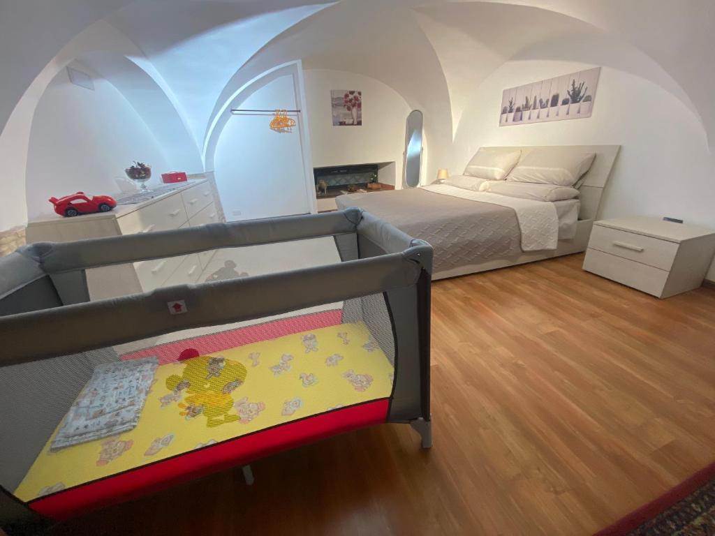 een slaapkamer met een bed en een wieg in een kamer bij Casa trinità in Catania