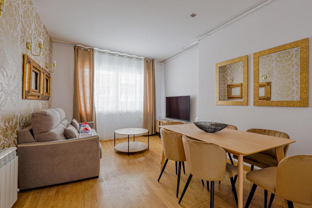 ein Wohnzimmer mit einem Tisch und einem Sofa in der Unterkunft Alcam Gold in Barcelona