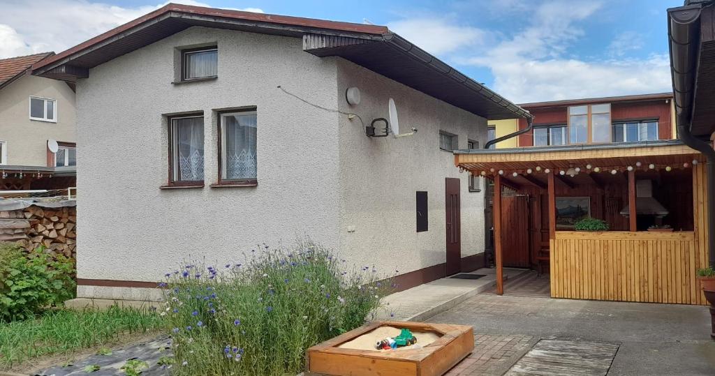 Casa blanca con porche y puerta de madera en Privat Zuzka, en Liptovský Mikuláš
