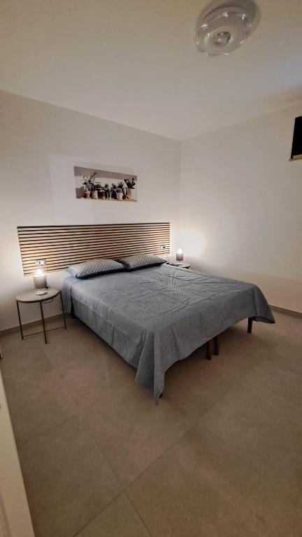 a bedroom with a large bed with a blue blanket at "Casa Vacanza Greci" in Greci