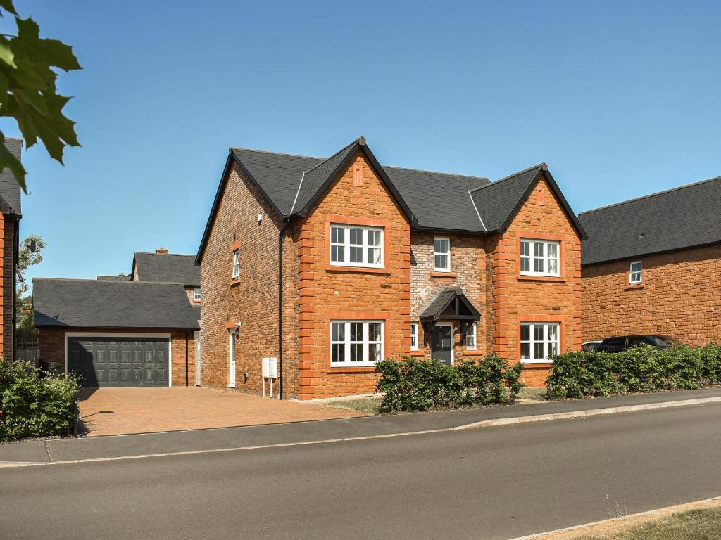 a brick house with a black roof on a street at Centurion Rise in Penrith