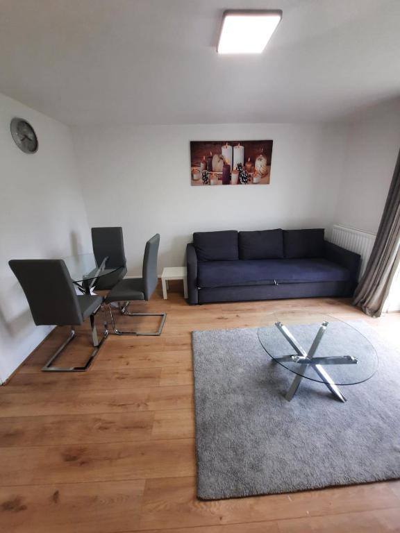 a living room with a blue couch and two chairs at TWO BEDROOM LUXURY HOUSE in Thamesmead