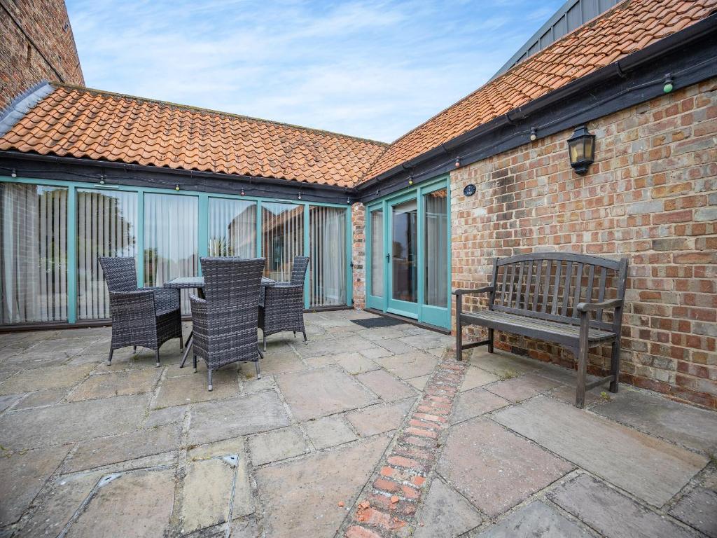 a patio with a bench and a table and chairs at The Lodge - Uk44516 in North Thoresby