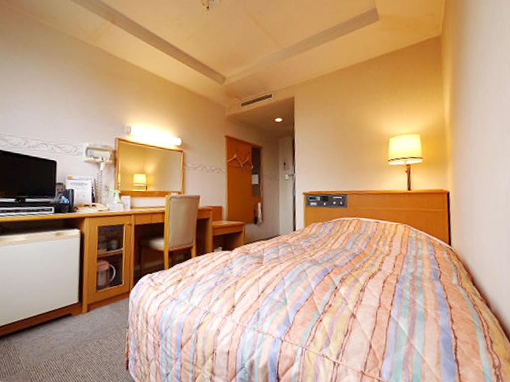 Habitación de hotel con cama y escritorio en Hotel Fukui Castle - Vacation STAY 58682v, en Fukui