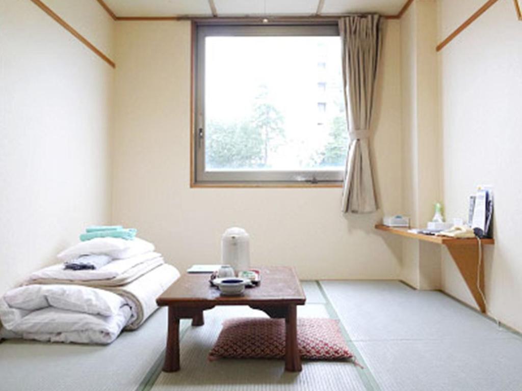 福井市にあるHotel Fukui Castle - Vacation STAY 58699vのテーブルとベッド、窓が備わる客室です。