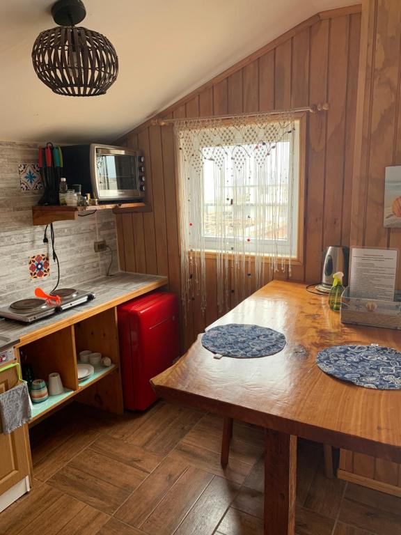 a kitchen with a wooden table in a room at Suite Matrimonial 2 Rocas del Mar in Pichilemu