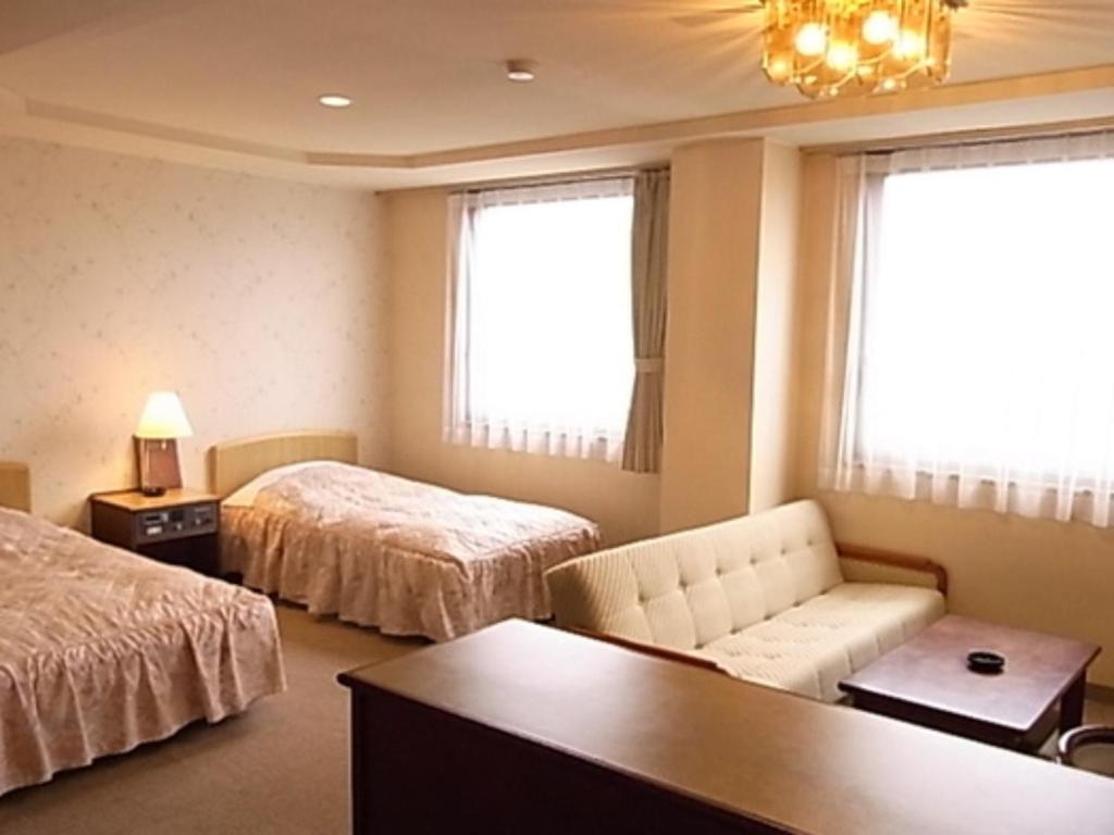 pokój hotelowy z 2 łóżkami i kanapą w obiekcie Hotel Fukui Castle - Vacation STAY 58712v w mieście Fukui