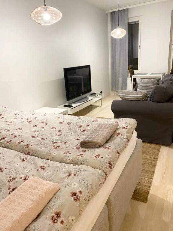 a living room with two beds and a flat screen tv at PEURANIITTY 3 - Modern easygoing apartment in Espoo