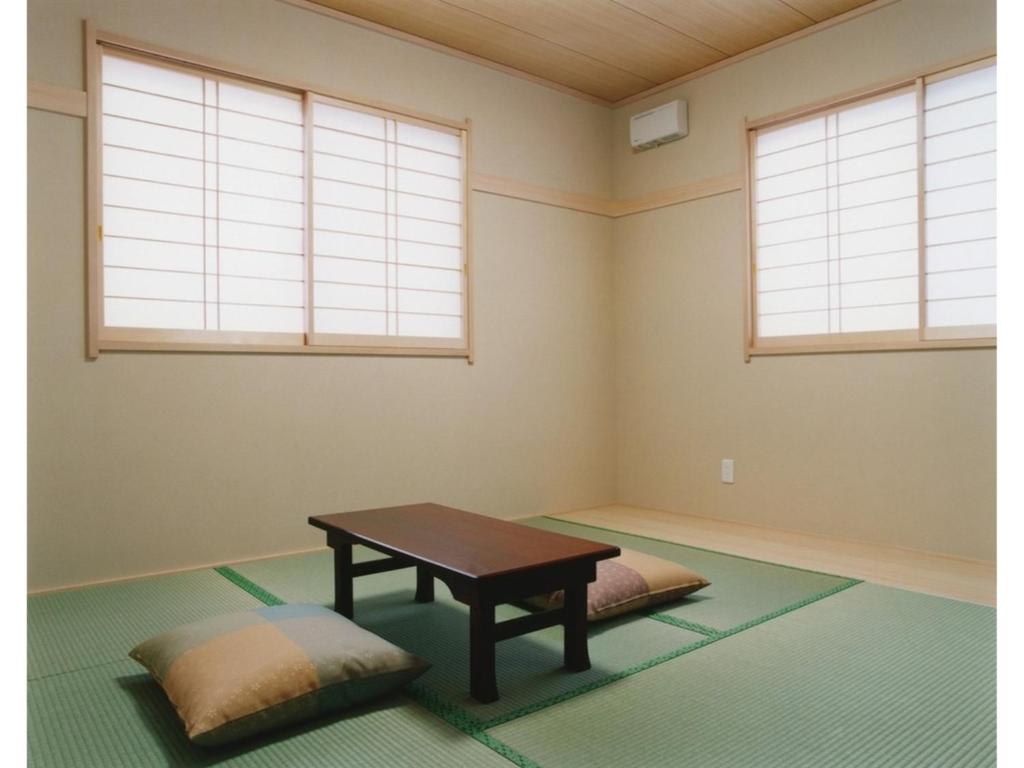 a meditation room with a table and two windows at Business Ryokan Fukuzumi - Vacation STAY 01039v in Shizuoka