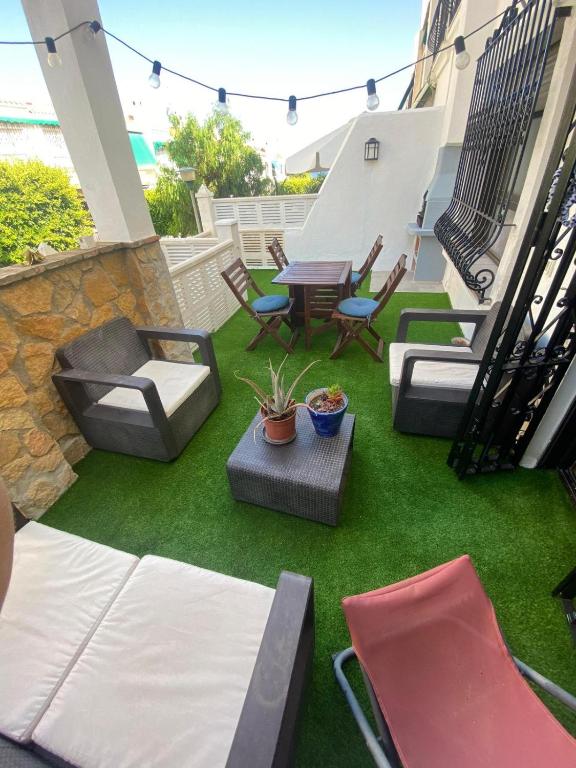 un patio con césped, sillas y una mesa en Casa en Aguadulce Playa, en Aguadulce