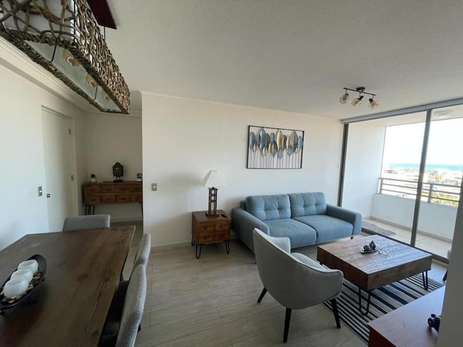 a living room with a blue couch and a table at Acogedor departamento centro Iquique in Iquique